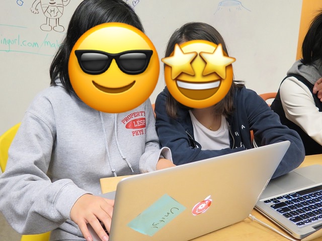 A photo of two girls working at a laptop