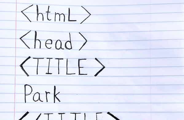 A photograph of a handwritten HTML document on lined paper